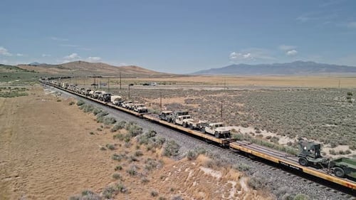 Train moving through the Utah desert loaded with military vehicles