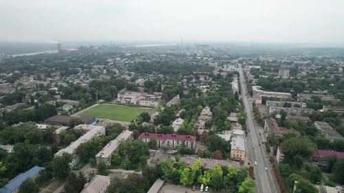 Aerial View of the City Near a Large Industrial Plant with Pipes and Smoke