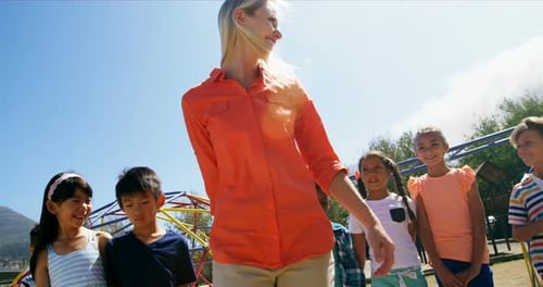 Trainer and schoolkids having fun in playground