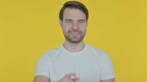 Young Man Pointing at the Camera on Yellow Background