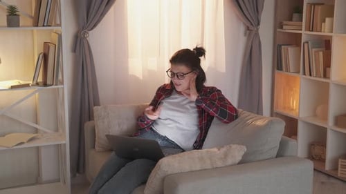 Woman Working on Laptop at Home on Couch