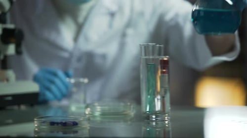 Lab Assistant Pouring Needed Reagent Into Beaker to Create Chemical Solution