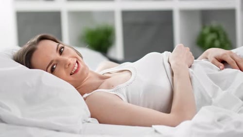 Happy Morning Woman with Natural Beauty Lying in Bed Relaxing