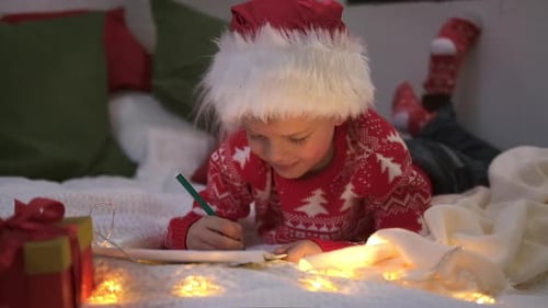 Child Writing a Letter to Santa on Bed