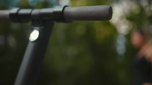 Focus Rack From Electric Scooter Handle to a Confident Fit Woman Ready to Start a Ride