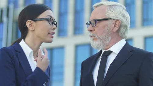 Business Professionals Discuss Finances in Front of Building