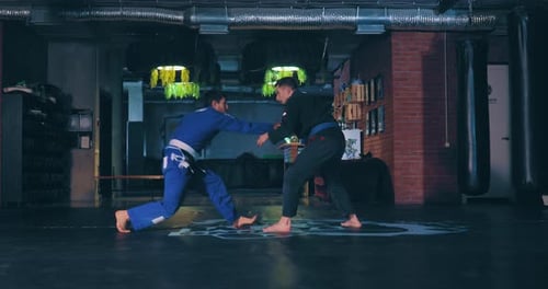 Men Grappling in Jujutsu Match in Gym