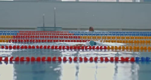 Professional Swimmer Trains in the Pool Actively Rowing with His Hands Freestyle