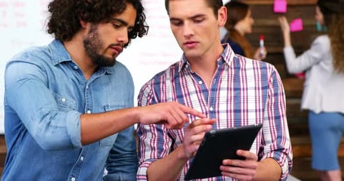 Men Work Together Using a Tablet in Office