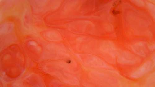 Abstract Orange and White Liquids Mixing Close Up
