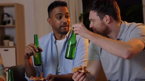 Happy Male Friends with Beer Eating Pizza at Home