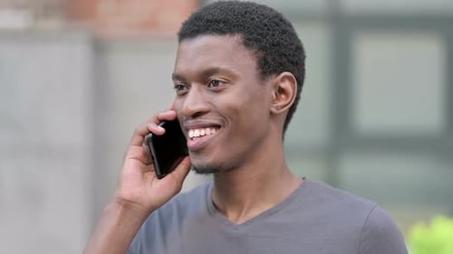 Young Adult on Mobile Phone Talking and Smiling