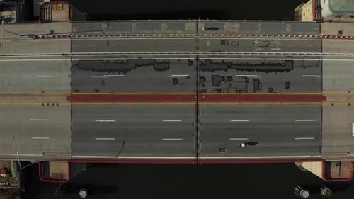 Aerial Birds Eye Overhead Top Down Aufsteigende Schussautos fahren auf mehrspuriger Straßenbrücke über Wasser