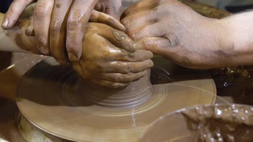Hands Forming Pottery on Wheel