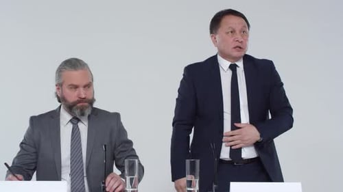 Two Men in Suits Speaking at a Table