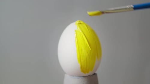 Gelb gefärbtes Ei auf grauem Hintergrund. Ostern