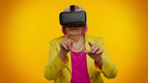Senior Woman Using VR Headset with Yellow Background