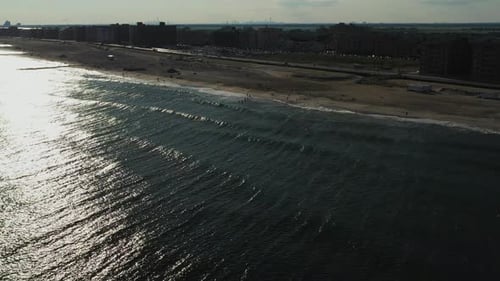 aerial drone crane shot over the ocean, rise up as the camera tilts down over the water, focusing on
