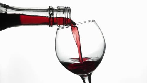 Vin rosé. Vin rouge Verser dans un verre à vin sur fond blanc