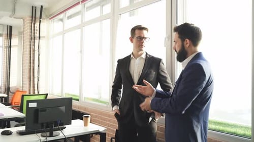 Men in Suits Discuss Business at Office