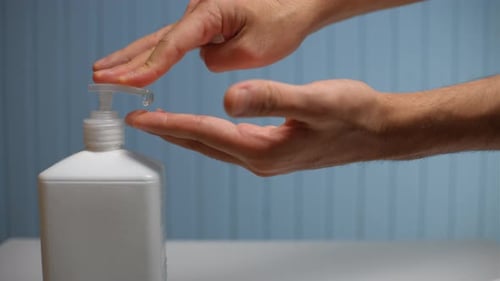 Man Dispensing and Applying Hand Sanitizer