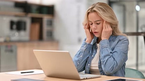Woman with Headache Working at Laptop