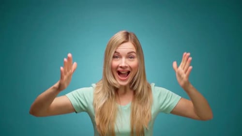 Excited Blonde Woman Celebrates with Hands Raised