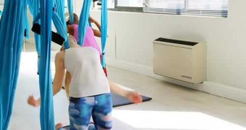 Women Doing Aerial Yoga Poses in Studio