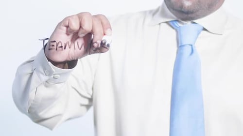 Man Writes 'Teamwork' on Glass in Office