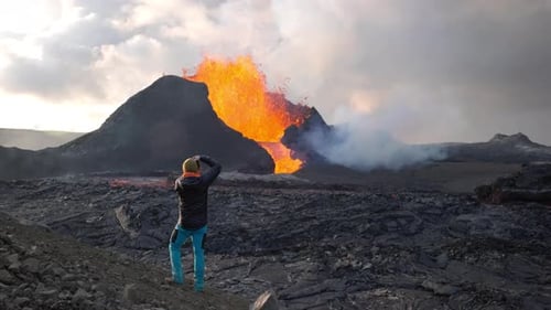 Man Photographing Lava Flowing From Erupting Fagradalsfjall Volcano