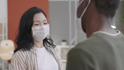 Asian Girl Greeting Colleague in Office