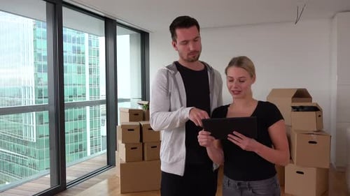 Couple Planning New Apartment with Tablet and Boxes