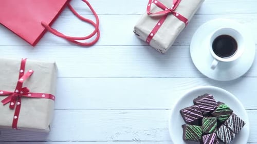 Top View of Man's Hand Holding a Gift Box on Table