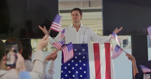 Man Giving Speech While People Wave Flags