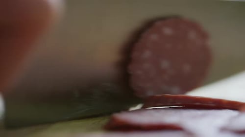 Slicing Delicious Sausage on Wooden Cutting Board