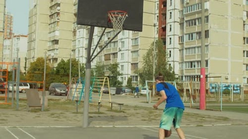 Young Adult Playing Basketball on Urban Court