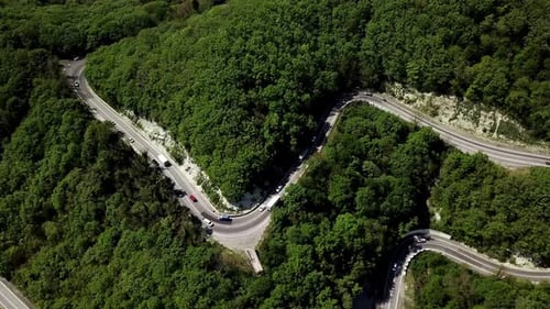 Aerial View of a Curved Winding Road with Cars Passing