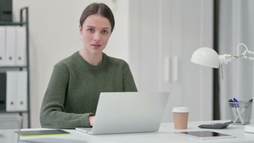 Woman at Desk Giving a Thumbs Up