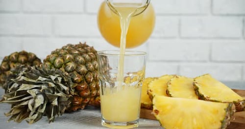 Pineapple Juice Pouring into a Glass