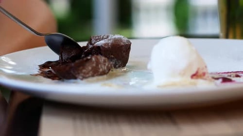 Women eating chocolate cake in a summer cafe. Liquid chocolate flows smoothly out of the cake