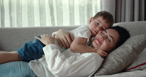Loving Mother and Son Cuddling on Couch