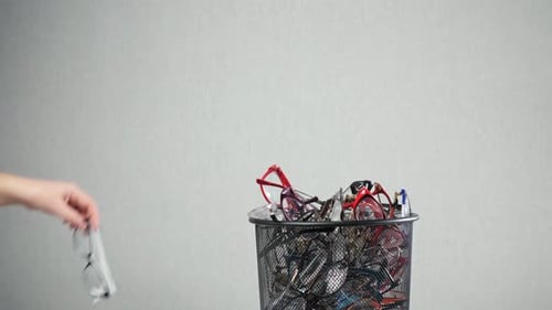 Woman Throws Glasses on Pile Inside of Rubbish Bin in Optics