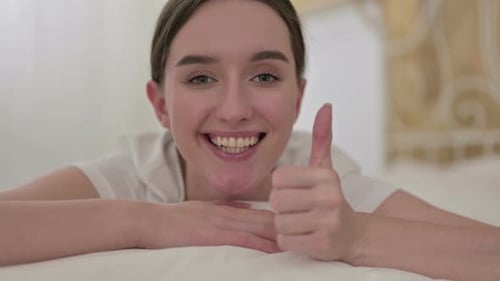 Close Up of Cheerful Young Woman Doing Thumbs Up in Bed