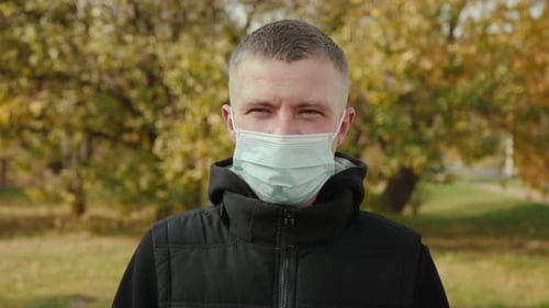Adult Wearing a Mask Outdoors in Autumn