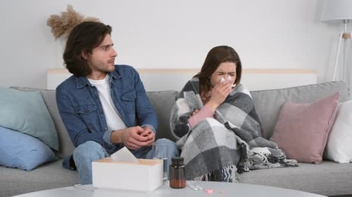 Woman Sick on Couch with Man Present