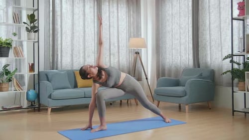 Young Asian Athletic Female Exercising, Stretching And Practicing Yoga At Home. Healthy Lifestyle