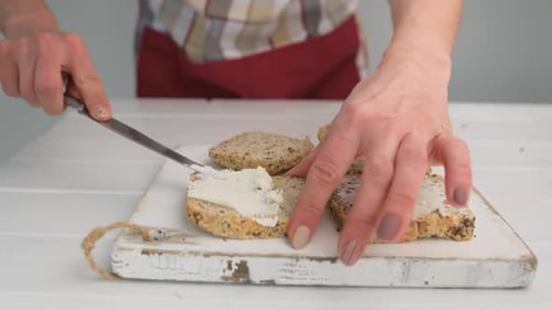Woman Spreads Cream Cheese on Healthy Bread