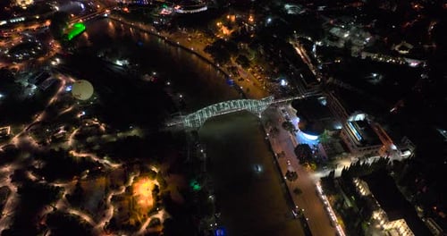Night aerial view of Bridge of Peace and beautiful cityscape in the center of Tbilisi, Georgia 2022