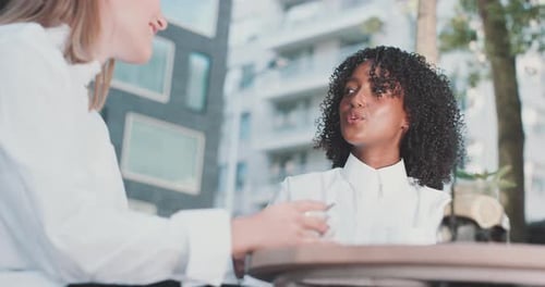 Zwei Frauen diskutieren am Tisch über Geschäfte