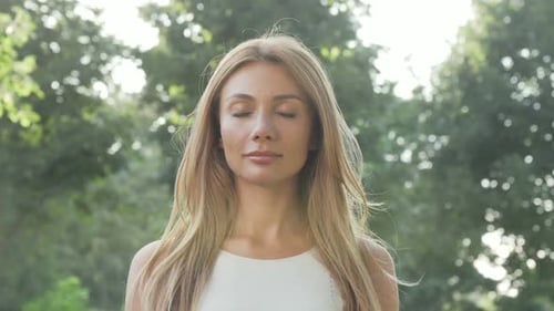 Beautiful Happy Woman Enjoying Relaxing Outdoors in the Park in Summer Evening